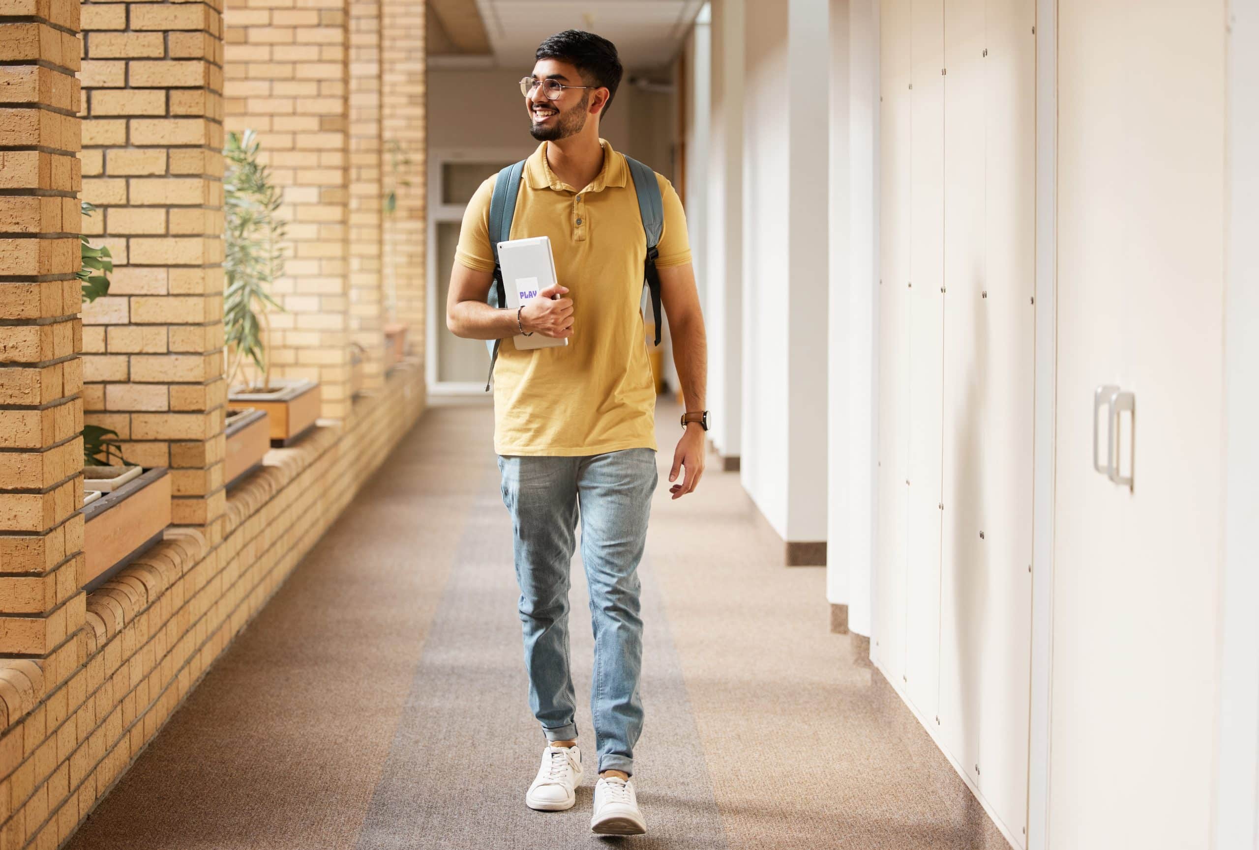 Deeltijd studeren door een jonge man die over de campus loopt.