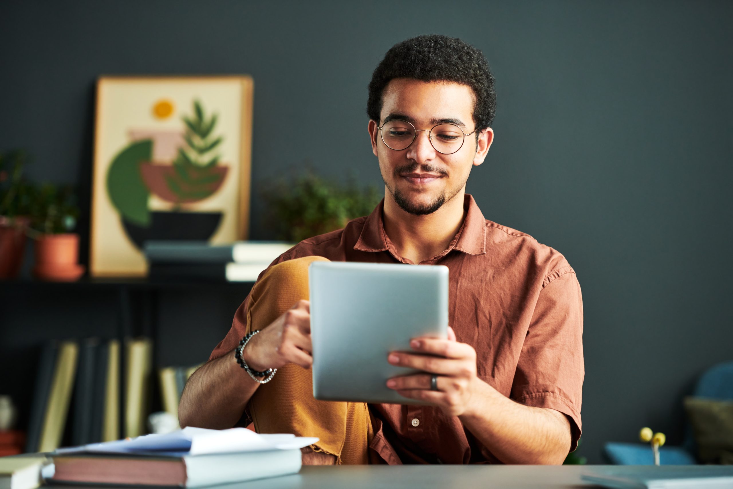 Jonge man zoekt zorgverzekering voor studenten op zijn tablet