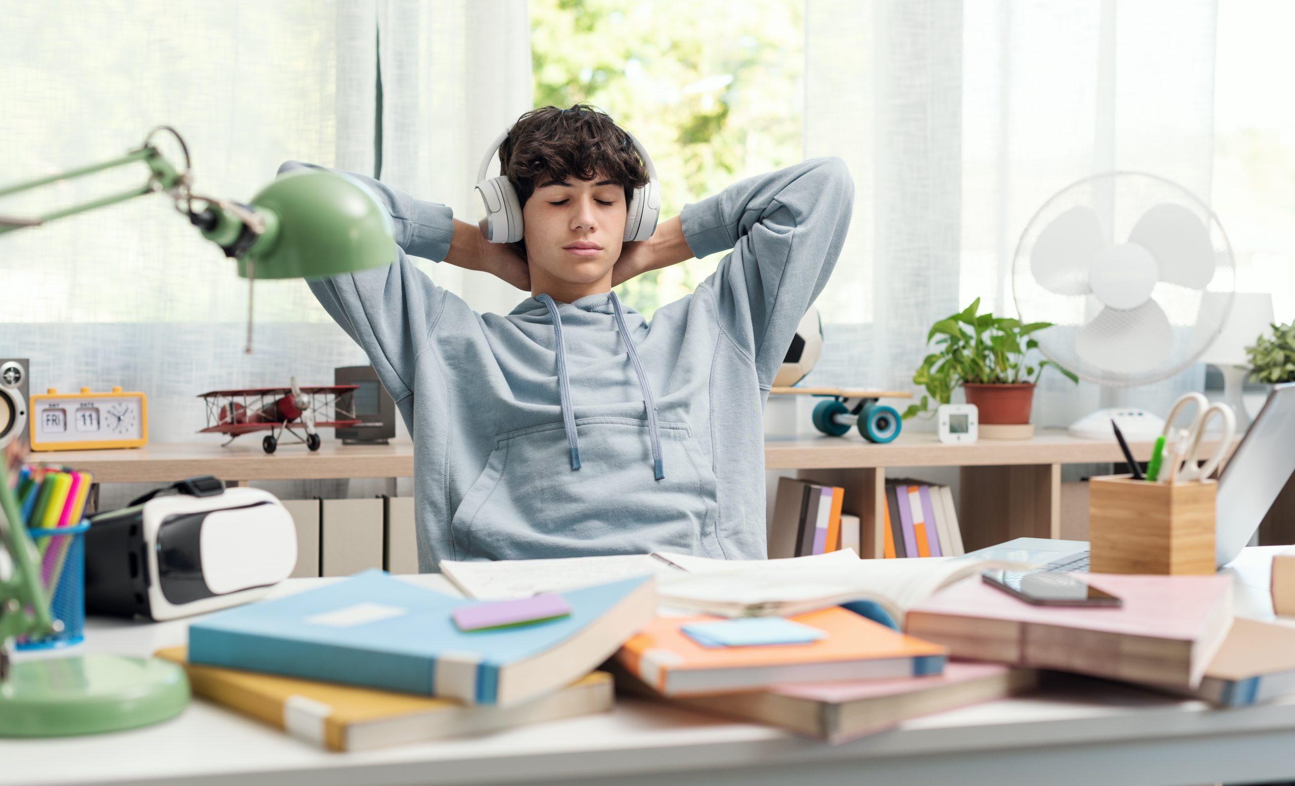 jongen met koptelefoon en boeken