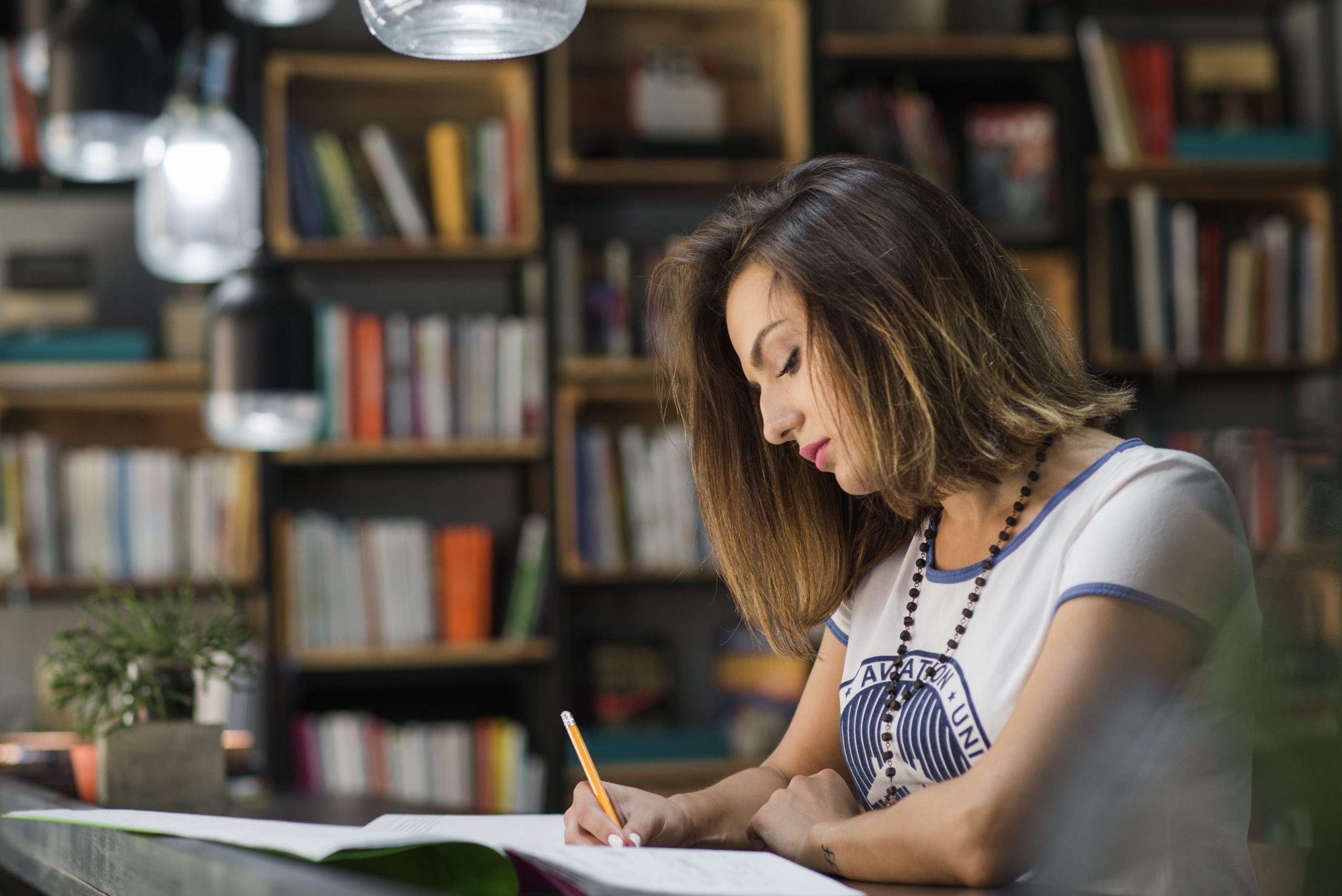 girl-sitting-table-with-notebooks-writing